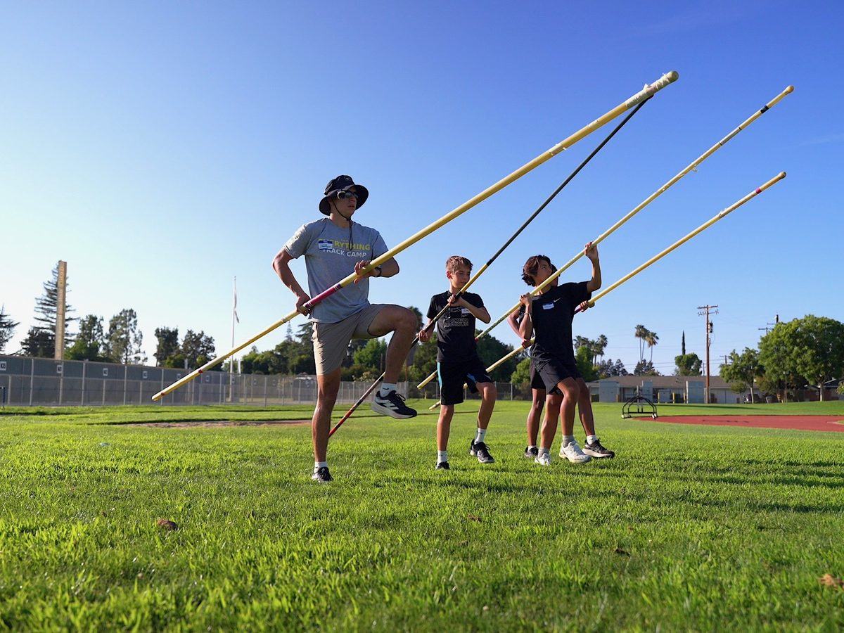 Coach teaching pole vault technique to a small group