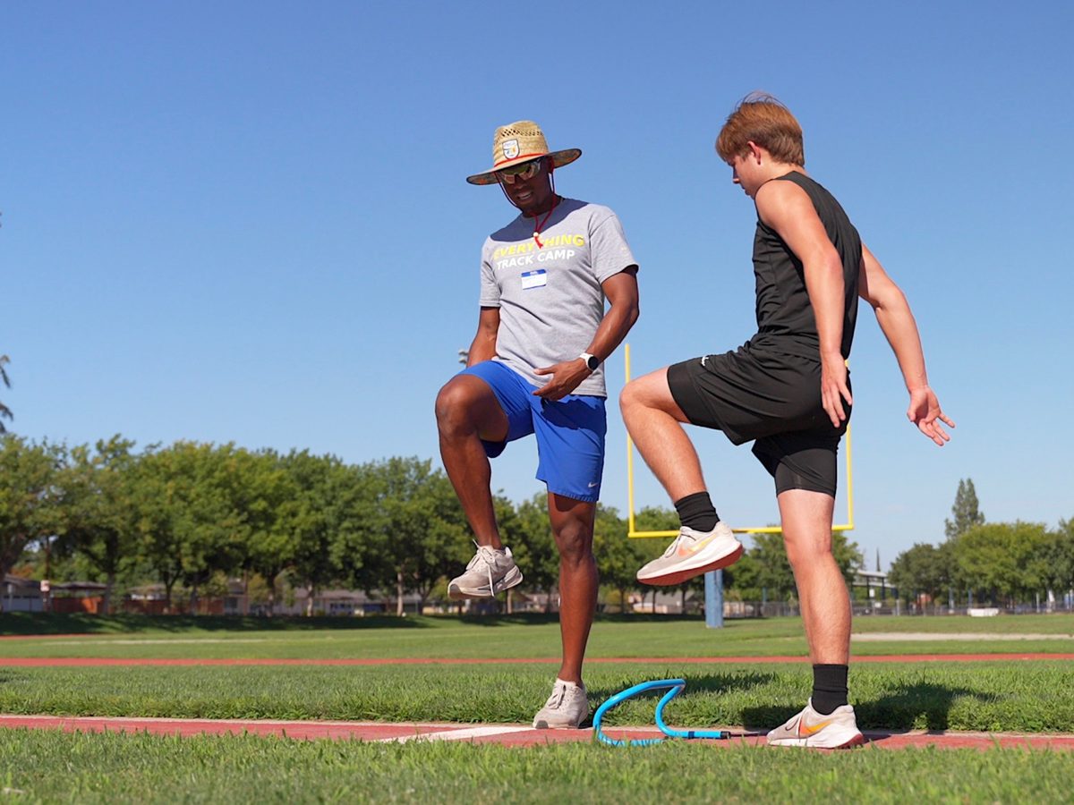 Coach leading a dynamic warmup drill with an athlete
